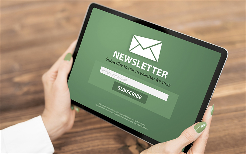 Person holding iPad screen says Subscribe to our newsletter for free.