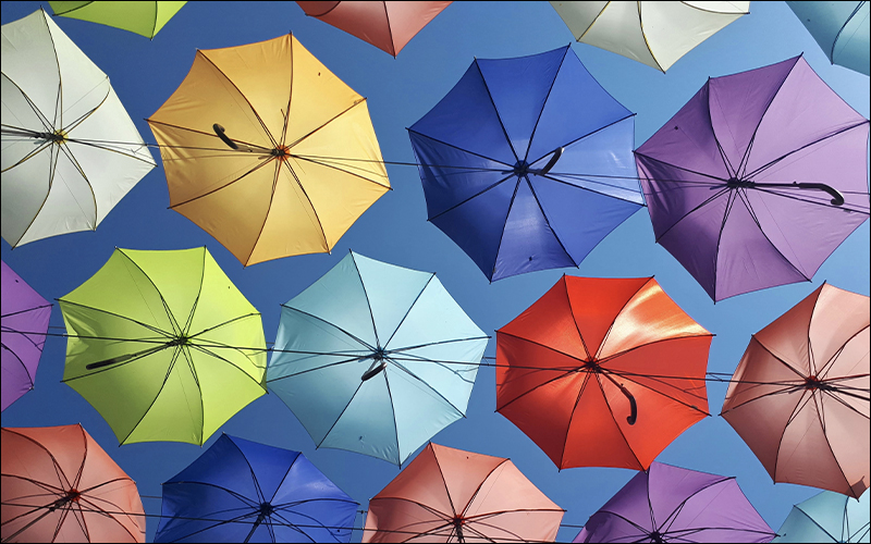 A bunch of colorful umbrellas from underneath.