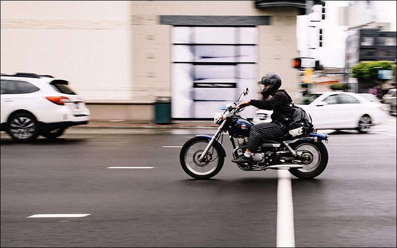 Motorcyclist on road with other cars.