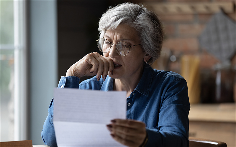 Woman concerned, reading letter.