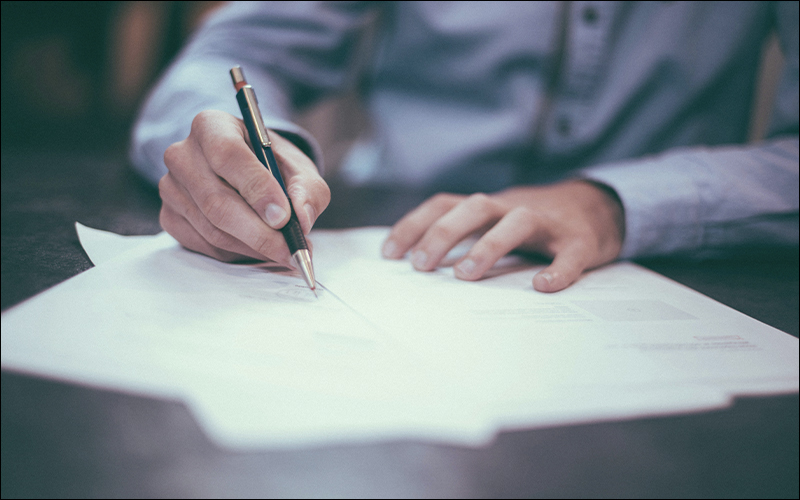 Person writing on documents.