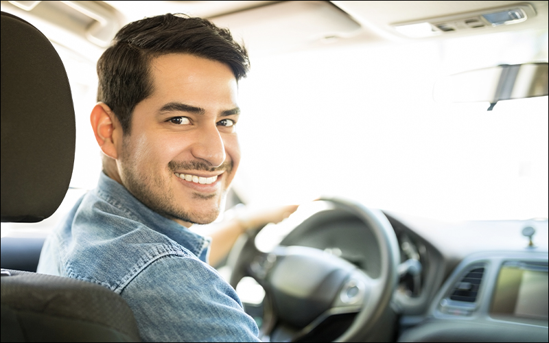Man smiling while driving.