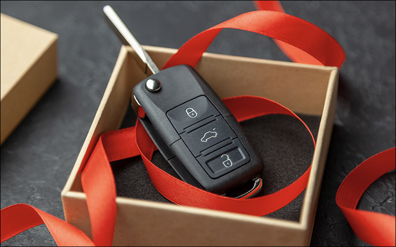 Car key in gift box with red ribbon.