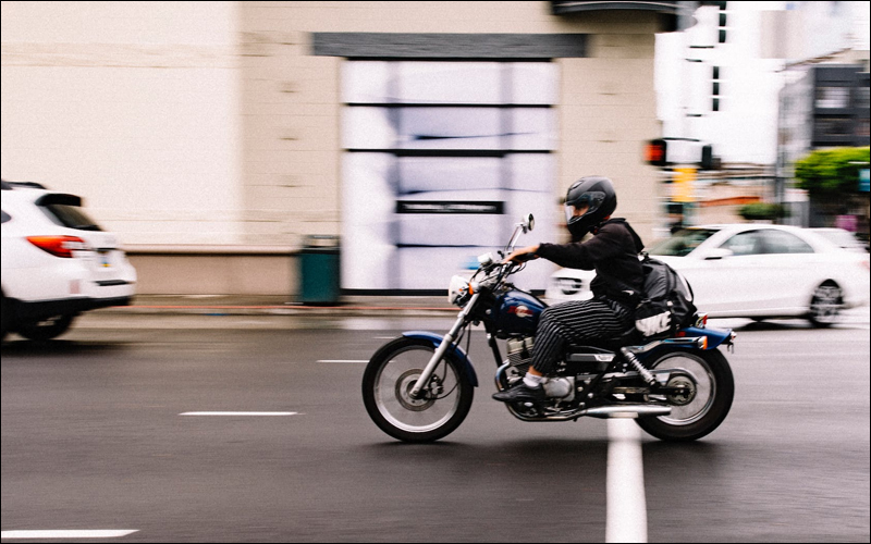 Motorcyclist on road with other cars.