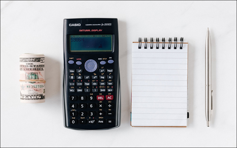 Money, calculator, notepad, and pen.