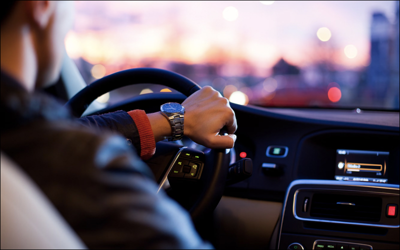 Man driving car, view from back seat.