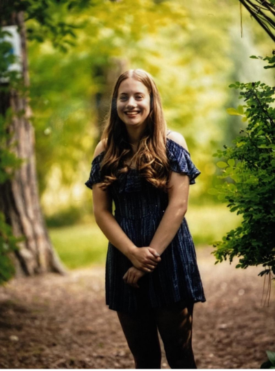 teenage girl in blue top standing on a path
