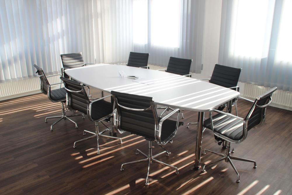 a white table surrounded by 8 black chairs