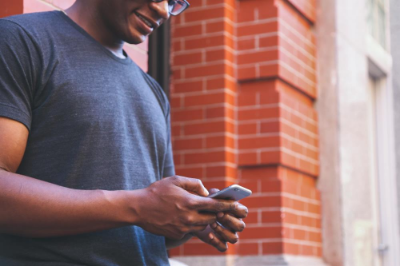 Man in gray shirt looking at a cell phone